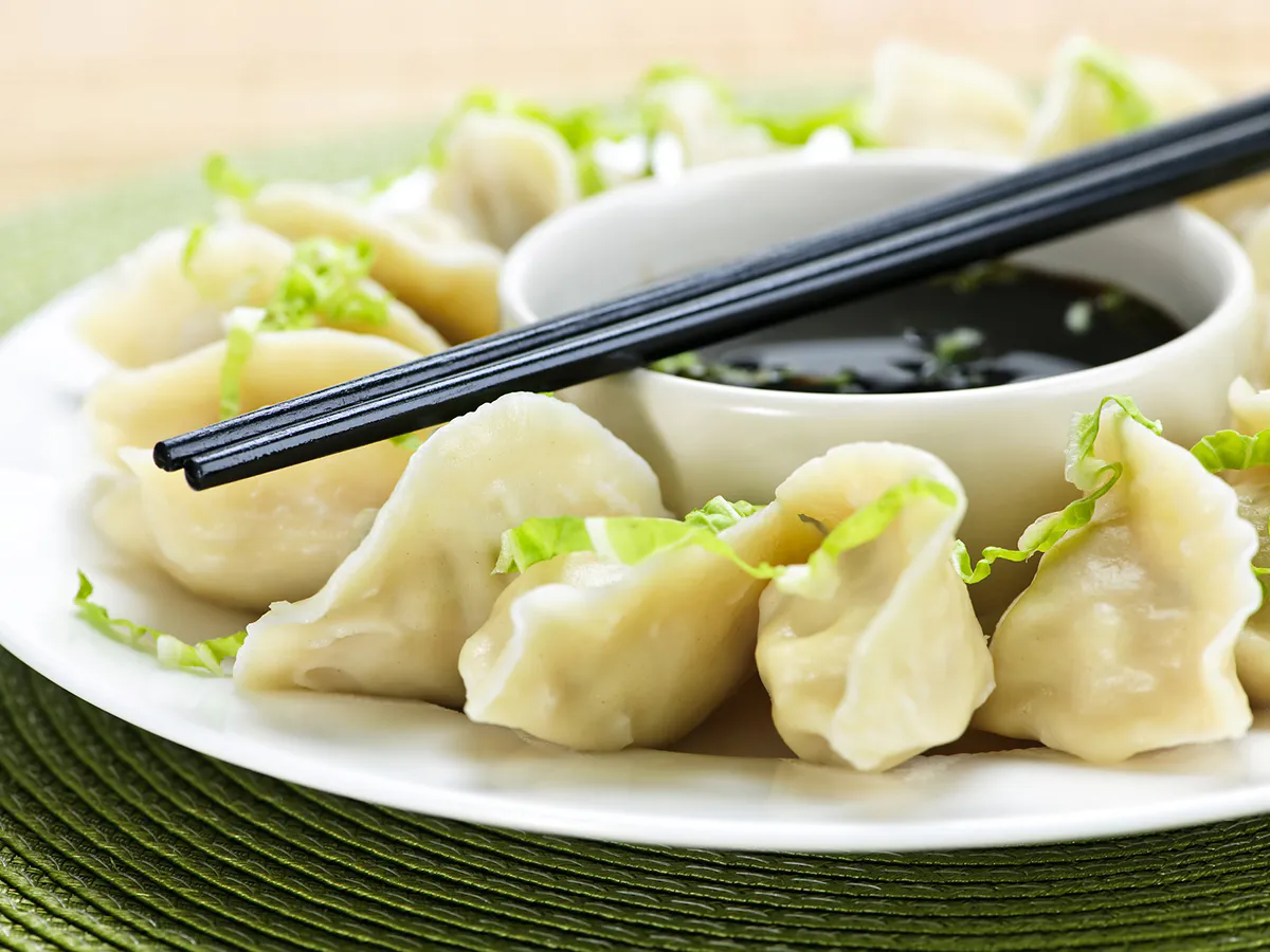 Soft boiled dumplings paired with soy dipping sauce and chopsticks at Endless Art And Food, an Asian Fushion Restaurant in Catskill